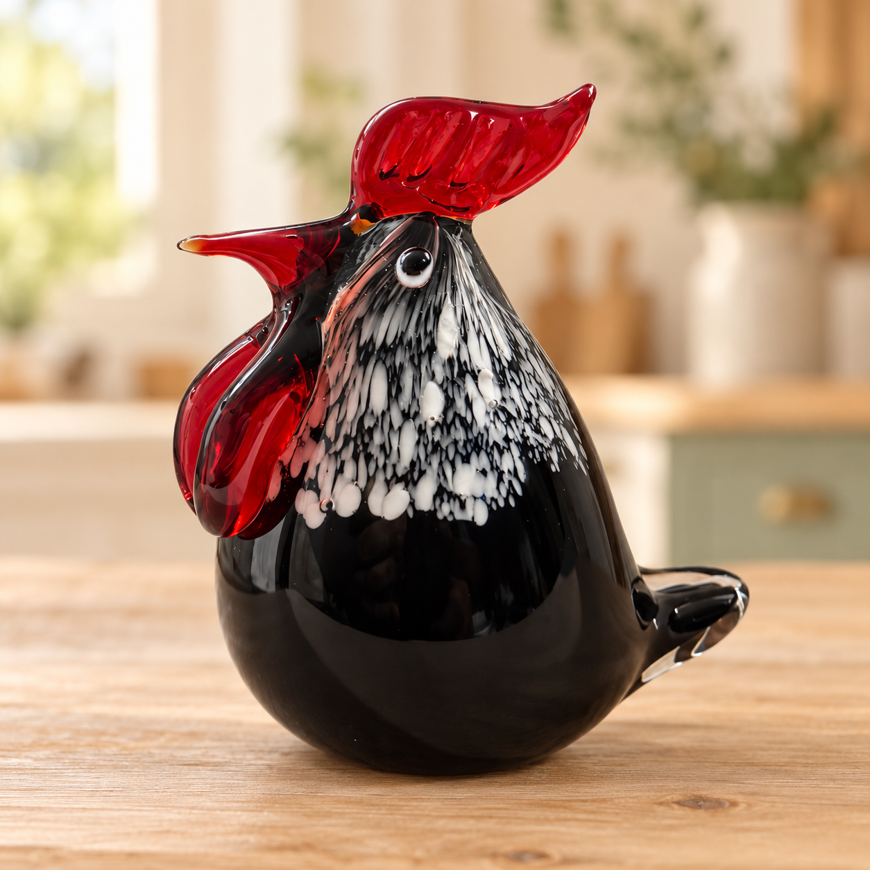 Black and white speckled glass rooster with ruby red comb on a farmhouse kitchen background