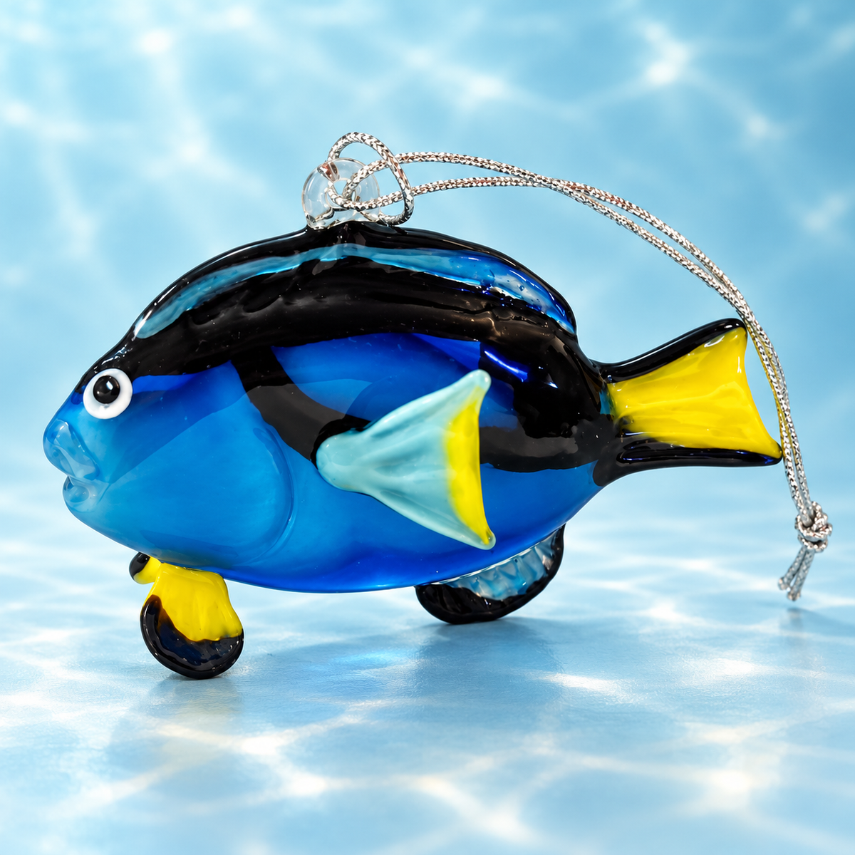 Dynasty Gallery blue tang glass ornament with yellow tail and silver hanging cord on aqua background