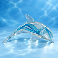 Dynasty Gallery clear glass dolphin with blue and white ribbons on ocean-blue background, shown in normal light