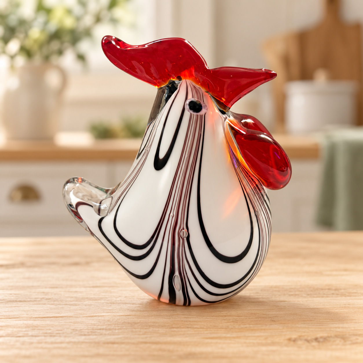 White glass rooster with nested black swirls and red comb on farmhouse kitchen background
